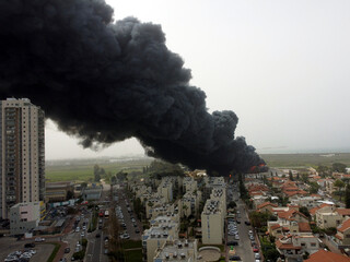 Acre, Israel - April 8 2022: Bahai construction site caught fire and huge smoke pillar covering residential neighborhood 