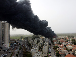 Acre, Israel - April 8 2022: Bahai construction site caught fire and huge smoke pillar covering residential neighborhood 