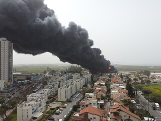 Acre, Israel - April 8 2022: Bahai construction site caught fire and huge smoke pillar covering residential neighborhood 