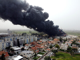 Acre, Israel - April 8 2022: Bahai construction site caught fire and huge smoke pillar covering residential neighborhood 