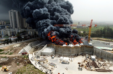 Acre, Israel - April 8 2022: Bahai construction site caught fire and huge smoke pillar covering residential neighborhood 