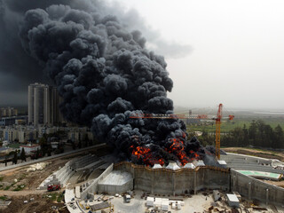 Acre, Israel - April 8 2022: Bahai construction site caught fire and huge smoke pillar covering residential neighborhood 