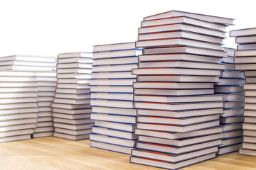 Large stacks of books on a wooden table isolated on a white background.