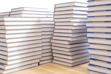 Large stacks of books on a wooden table isolated on a white background.
