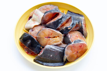 Catfish cut pieces in yellow plate on white background.