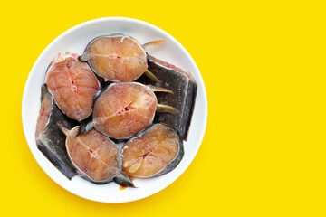 Catfish cut pieces on yellow background.
