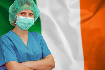Female surgeon doctor or intern wearing protective mask and hat background of the Ireland flag....