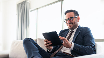 Businessman reading mails on a tablet