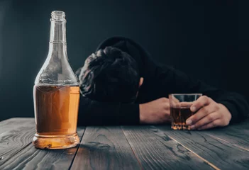 Rolgordijnen Depressed man drinking alcohol indoors © Daniel
