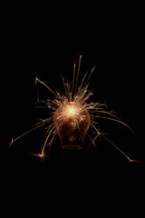 Incandescent lamp with sparks on a black background.