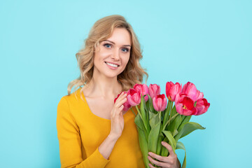 happy girl with spring tulip flowers on blue background