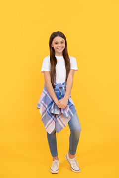 hipster child smile in casual clothes full length on yellow background