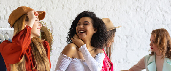 Young women at swap home party - clothes, shoes, bags, jewellery exchange between friends. Zero...