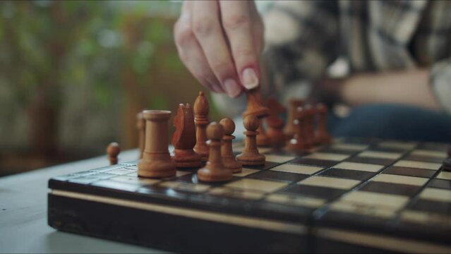 The girl puts the pieces on the chessboard, close up