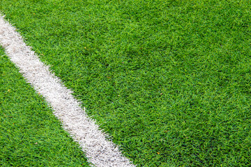 Fototapeta premium white markings on the artificial turf of a football field, desktop background, soft blur