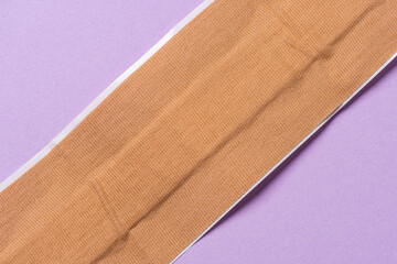 Long strip of brown medical plaster band aid.