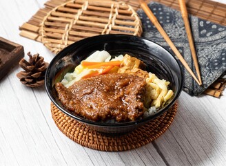 Meatloaf rice bento in a dish isolated on wood table side view taiwan food