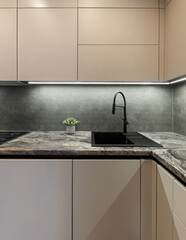 Vertical photo of Corner with sink in the interior of the kitchen with designer white cabinets...