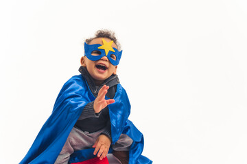 Studio shot of a little biracial boy toddler in a hero costume with a dark blue mask with a star...