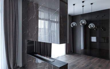 Biofireplace in the interior of a spacious bright studio apartment in Scandinavian style and warm pastel white and beige tones. 