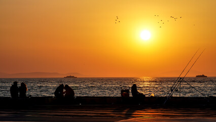 Fototapeta premium People enjoy spring at the seaside with a beautiful sunset 