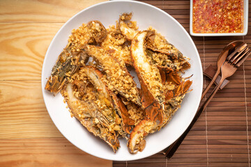 Stir fried flathead lobster with garlic and pepper on wooden table, Fried flathead lobster with garlic.