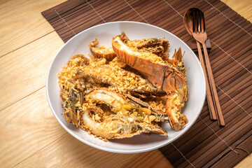 Stir fried flathead lobster with garlic and pepper on wooden table, Fried flathead lobster with garlic.