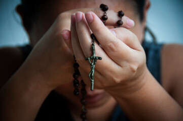 Women holding Holy Rosary while praying. Religious concept