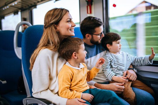 Beautiful happy young family travel together by fast train.