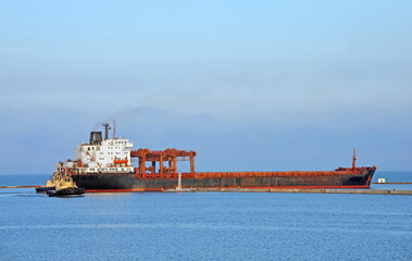 Tugboat assisting general cargo ship