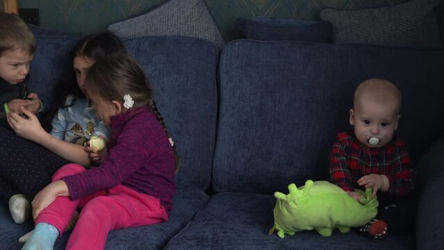 authentic 3 little preschool toddler minor children kids siblings watch cartoon playing games online chating on smartphone device laptop tablet together at home indoors. Family, childhood, friendship