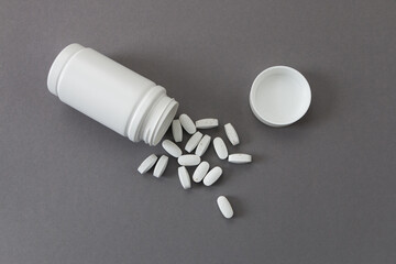 plastic bottle with multivitamins on gray background