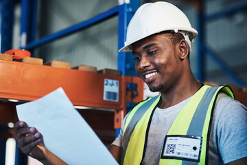 Time to put everything in its place. Shot of a handsome young contractor standing in the warehouse and reading paperwork.