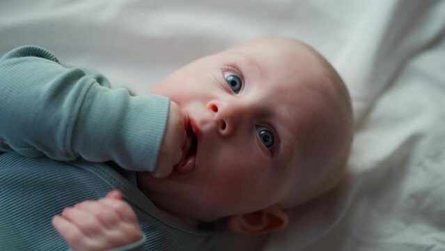  little toddler boy whit blue eye, smiling at camera, boy laughing and happy in bed, Toy overhead