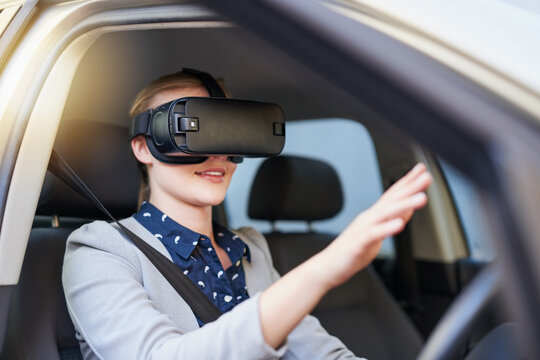 Integrating virtual reality into the driving experience. Cropped shot of a young businesswoman driving while wearing a virtual reality headset. - Powered by Adobe