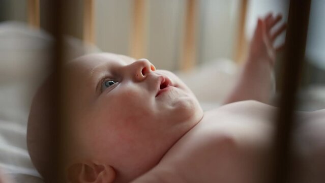 Little cute causian baby boy, smiling at camera, boy looks at the toy and is delighted. vertical video