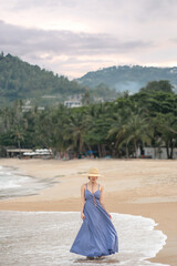 Fototapeta na wymiar Woman in blue dress pose on the beach.