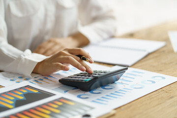 Close-up of business woman hands using a calculator to check company finances and earnings and budget.