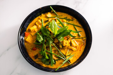 vegan tofu curry with bell peppers and mixed vegetables and spices topped with fresh herbs, healthy plant-based food