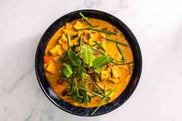 vegan tofu curry with bell peppers and mixed vegetables and spices topped with fresh herbs, healthy plant-based food