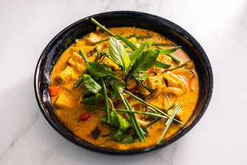 vegan tofu curry with bell peppers and mixed vegetables and spices topped with fresh herbs, healthy plant-based food