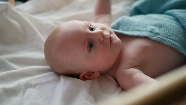 Little cute causian baby boy, smiling at camera, baby lying on his back. 
