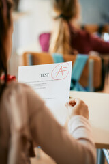 Cloe-up of schoolgirl getting A+ grade on exam at elementary school.