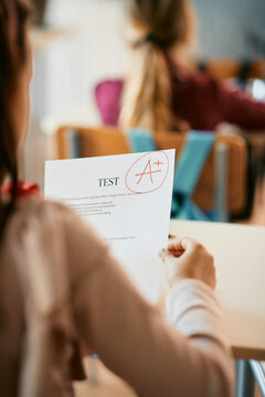 Cloe-up of schoolgirl getting A+ grade on exam at elementary school.