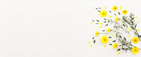 Fototapeta na wymiar Top view image of yellow chrysanthemum field flowers composition over wooden white background. Flat lay