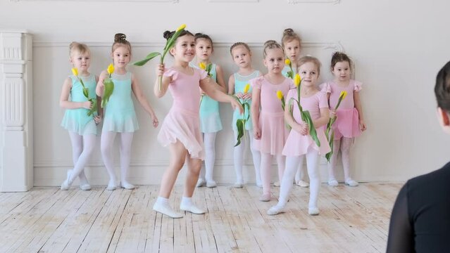 Little girls of the ballerina run to embrace the teacher.