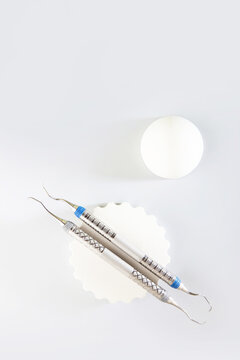 Modern medicine.Dental instruments on a light background on a white round podium.Vertical photo.Isolated object.Flat lay.Top view.Copy space.