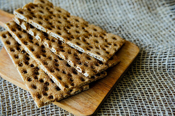 Rye crispbread. Crispy dry bread. Crispbread for sandwiches. Bread replacement. Wooden background. Side view.