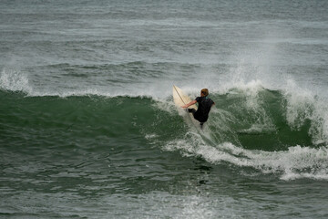 surfers at the beach catching waves on surfboards