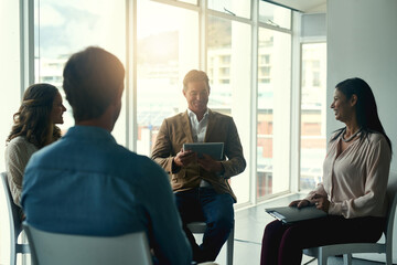 Putting brilliance to work. Shot of a group of happy coworkers having a meeting in a huddle in the office.
